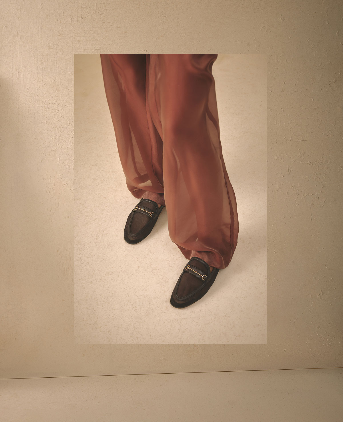 woman wearing a toffee colored, lightweight, sheer blouse and matching bottoms with the loraine mesh loafer in cafe noir